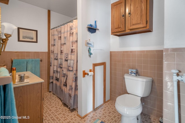 bathroom with toilet, vanity, and tile walls