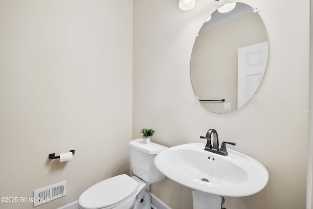 bathroom with toilet, sink, and crown molding