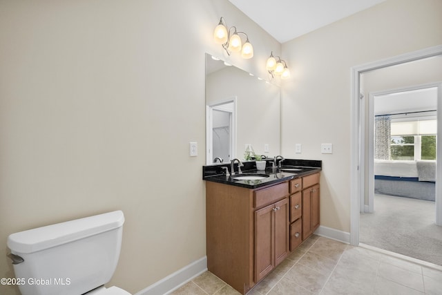 bathroom featuring toilet, vanity, and tile patterned flooring