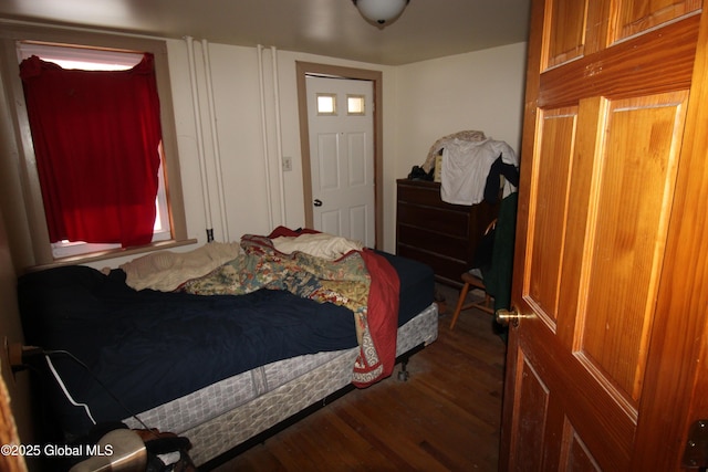 bedroom with dark wood-type flooring