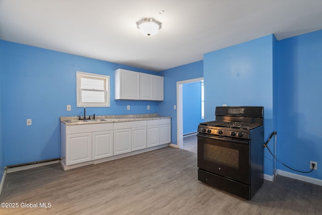 kitchen with black range with gas stovetop, white cabinets, light wood-type flooring, and sink