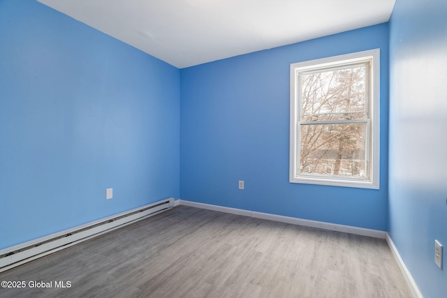 empty room with a baseboard heating unit and light hardwood / wood-style flooring