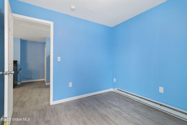 spare room with a baseboard radiator and light hardwood / wood-style flooring