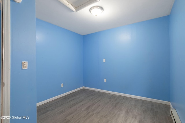 spare room with hardwood / wood-style flooring and a baseboard heating unit