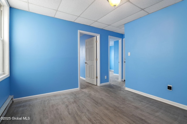 empty room featuring hardwood / wood-style flooring and a baseboard radiator