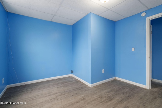 empty room featuring a drop ceiling and wood-type flooring