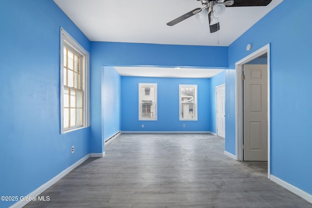 spare room with baseboard heating, wood-type flooring, and ceiling fan