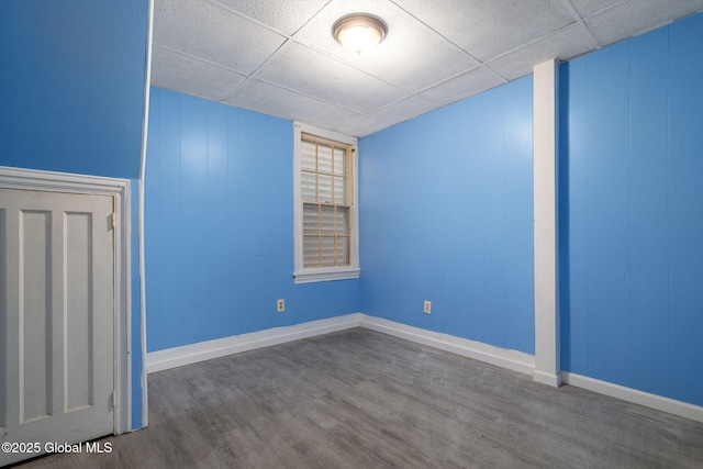 spare room featuring hardwood / wood-style flooring and a paneled ceiling