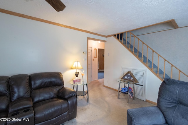 living room with a textured ceiling, ornamental molding, and carpet