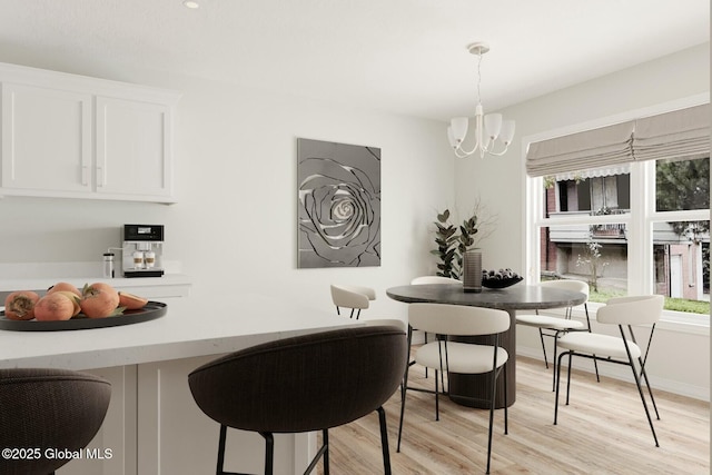 dining space featuring an inviting chandelier and light wood-type flooring