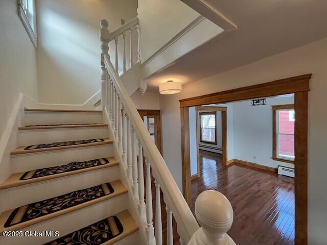 staircase featuring a baseboard radiator and wood-type flooring