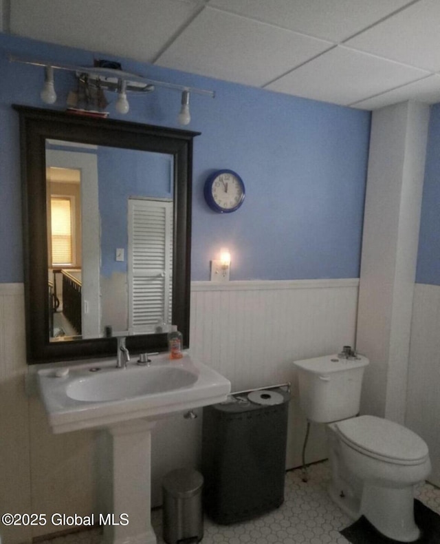 bathroom with toilet, tile patterned flooring, and a drop ceiling