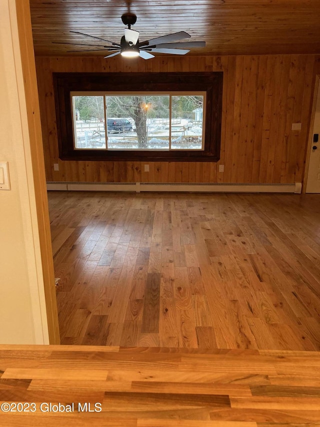 unfurnished room with hardwood / wood-style flooring, ceiling fan, a wealth of natural light, and wooden ceiling