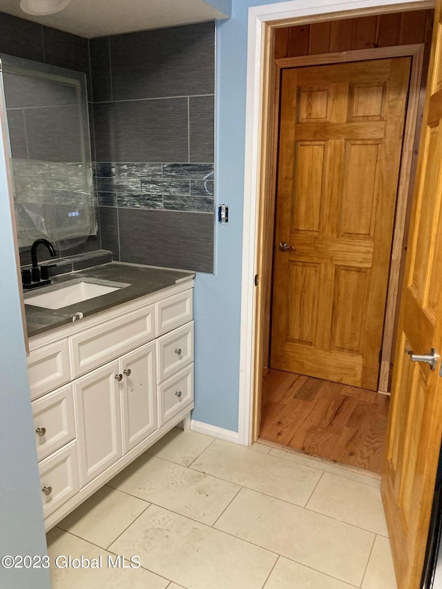 bathroom with tile patterned flooring, backsplash, and vanity