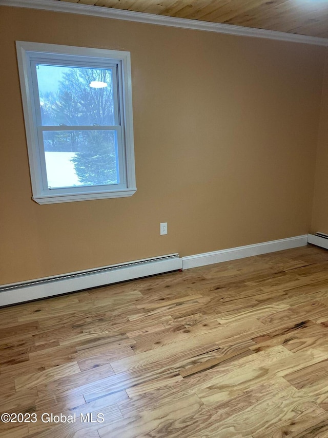 unfurnished room featuring a baseboard radiator, light hardwood / wood-style floors, and crown molding