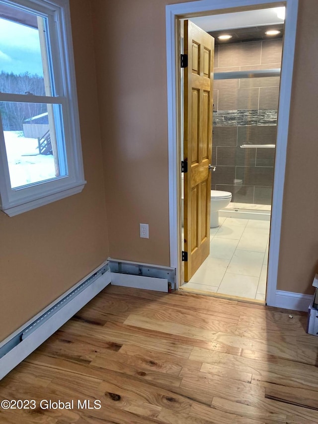 interior space with light hardwood / wood-style flooring and a baseboard heating unit