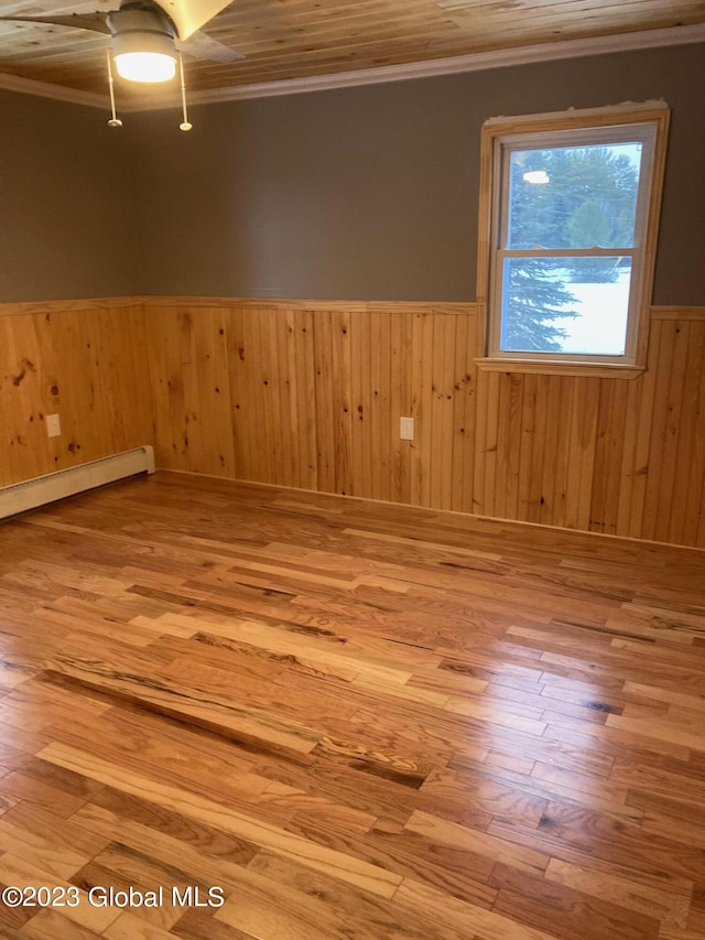 unfurnished room featuring a baseboard radiator, ornamental molding, and light hardwood / wood-style flooring