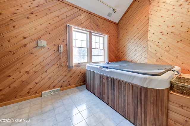 unfurnished bedroom featuring wood walls and lofted ceiling