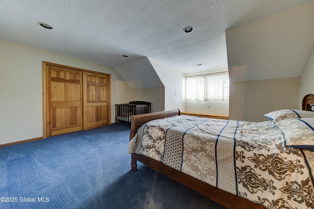 bedroom featuring a textured ceiling, vaulted ceiling, and carpet