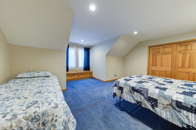 bedroom with vaulted ceiling, dark colored carpet, and a closet