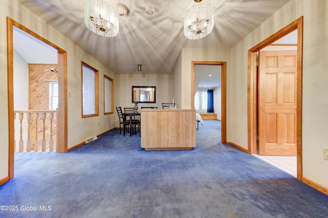 interior space featuring an inviting chandelier, pendant lighting, and carpet