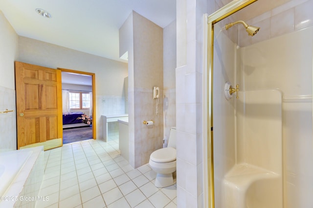 bathroom with tile walls, a shower, tile patterned floors, and toilet