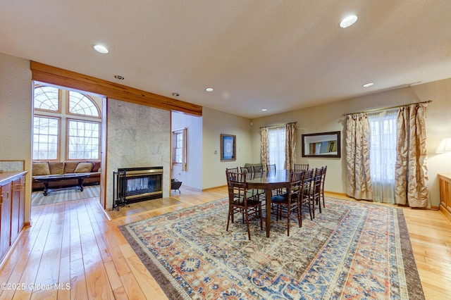 dining area with a fireplace and light hardwood / wood-style floors