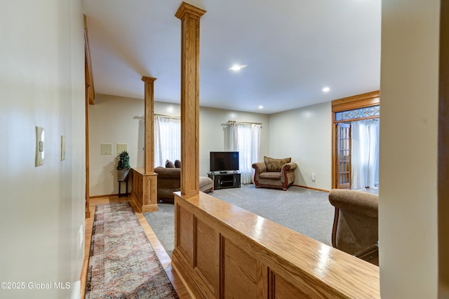 living room with ornate columns and light carpet