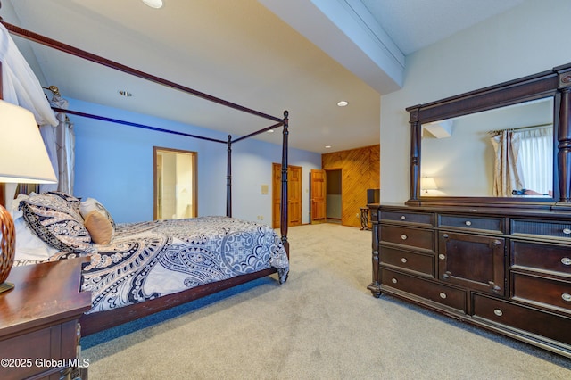 bedroom with light carpet and wood walls