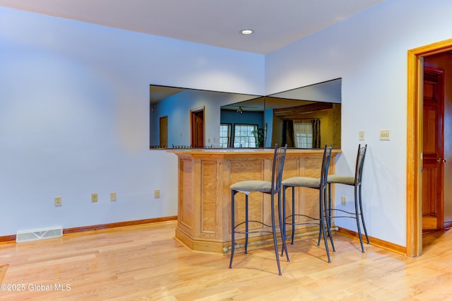 kitchen with a kitchen breakfast bar and light wood-type flooring