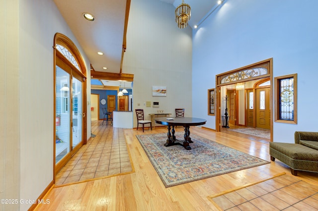 entryway featuring a notable chandelier, a towering ceiling, and hardwood / wood-style flooring