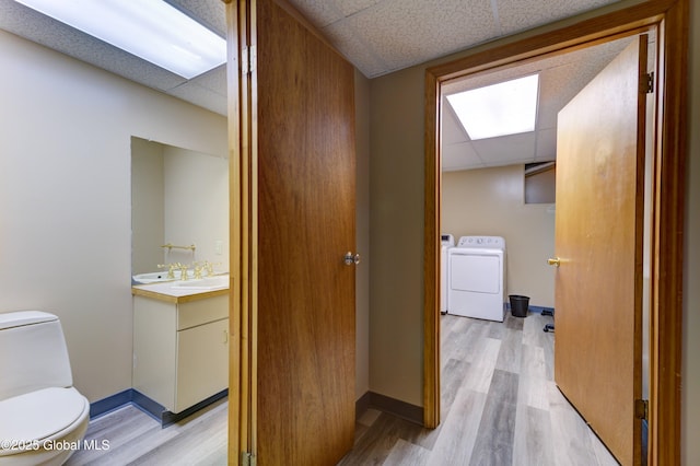 bathroom with vanity, toilet, hardwood / wood-style flooring, and a drop ceiling