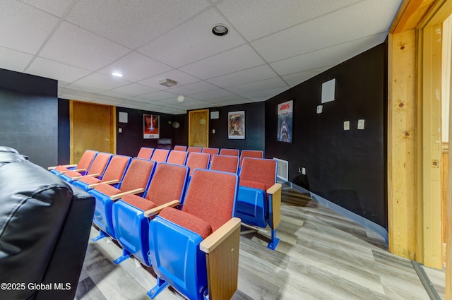 cinema featuring a paneled ceiling and hardwood / wood-style flooring