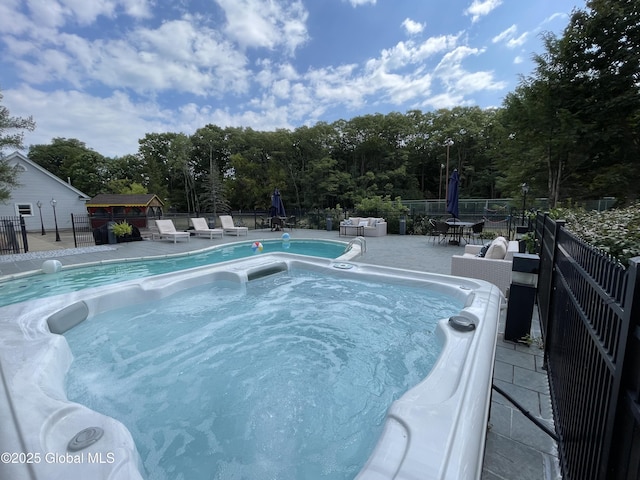 view of pool featuring a hot tub and a patio area