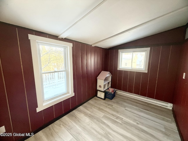 bonus room with lofted ceiling, a baseboard heating unit, light hardwood / wood-style flooring, and plenty of natural light