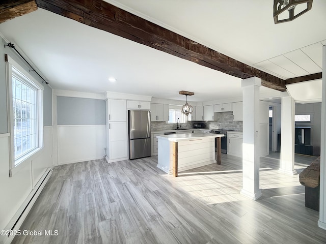 kitchen featuring stainless steel appliances, decorative backsplash, a kitchen island, decorative light fixtures, and a baseboard radiator