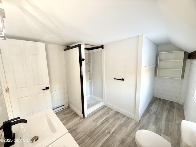 bathroom with lofted ceiling, a shower, baseboard heating, and hardwood / wood-style flooring