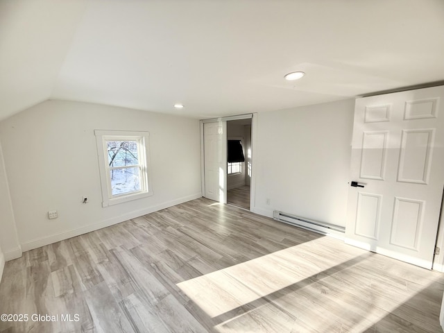 interior space featuring light hardwood / wood-style flooring, a baseboard radiator, and lofted ceiling