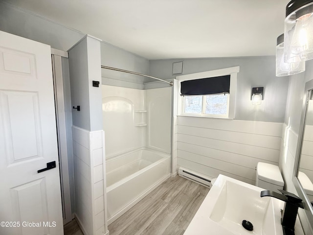 full bathroom with sink, lofted ceiling, wood-type flooring, washtub / shower combination, and a baseboard radiator