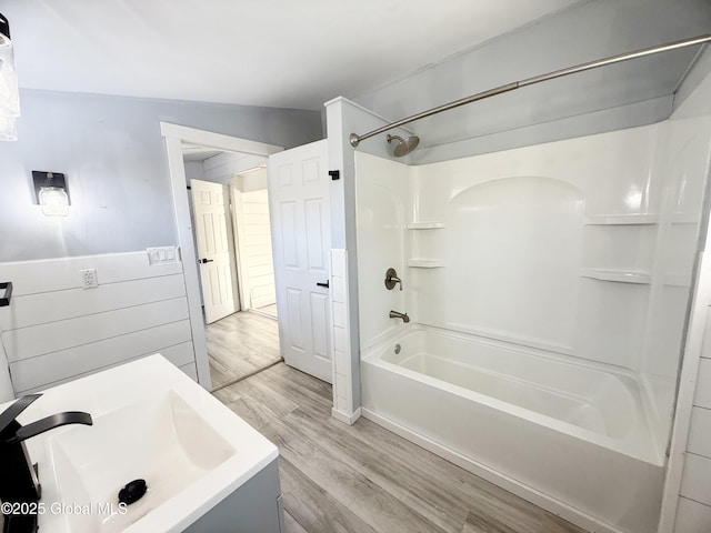 bathroom with shower / bathing tub combination, sink, and hardwood / wood-style floors