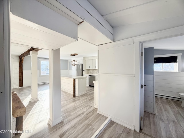 interior space featuring white cabinets, stainless steel appliances, plenty of natural light, and tasteful backsplash