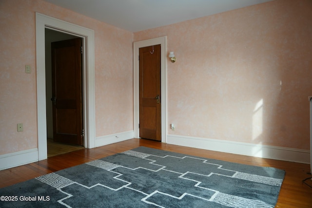 empty room with dark hardwood / wood-style flooring