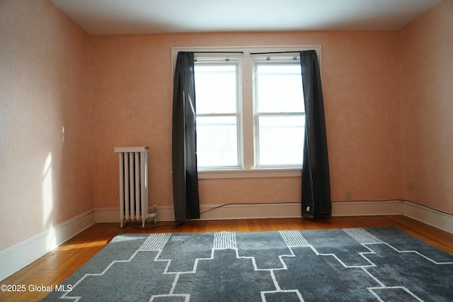 empty room featuring hardwood / wood-style floors and radiator