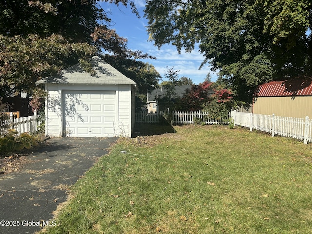 view of yard featuring a garage and an outbuilding