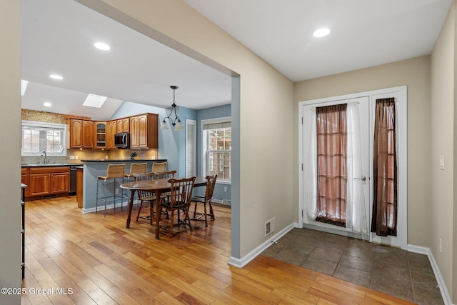 foyer with lofted ceiling, sink, and light hardwood / wood-style floors