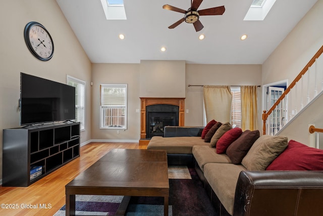 living room with ceiling fan, wood-type flooring, and high vaulted ceiling