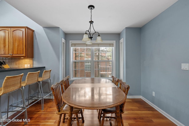 dining room with dark hardwood / wood-style floors and a chandelier