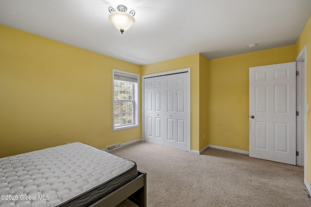 bedroom with light colored carpet and a closet