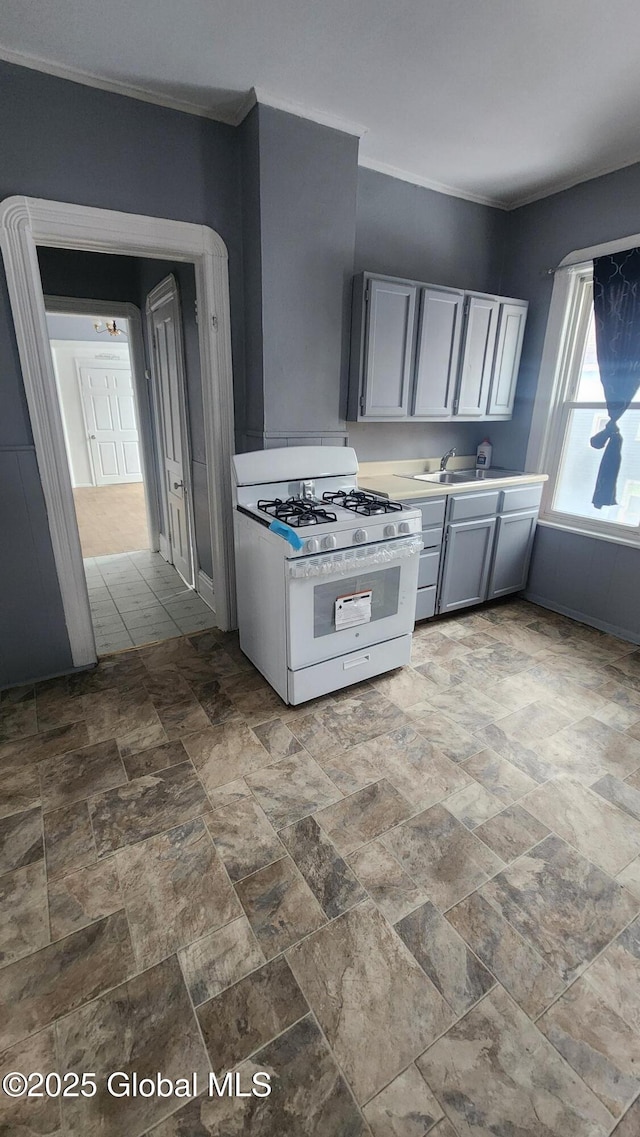 kitchen featuring sink, white gas stove, and gray cabinets