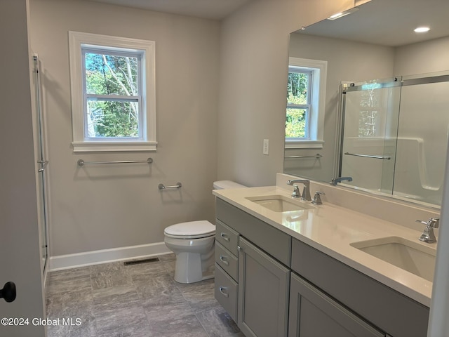 bathroom featuring vanity, toilet, and an enclosed shower